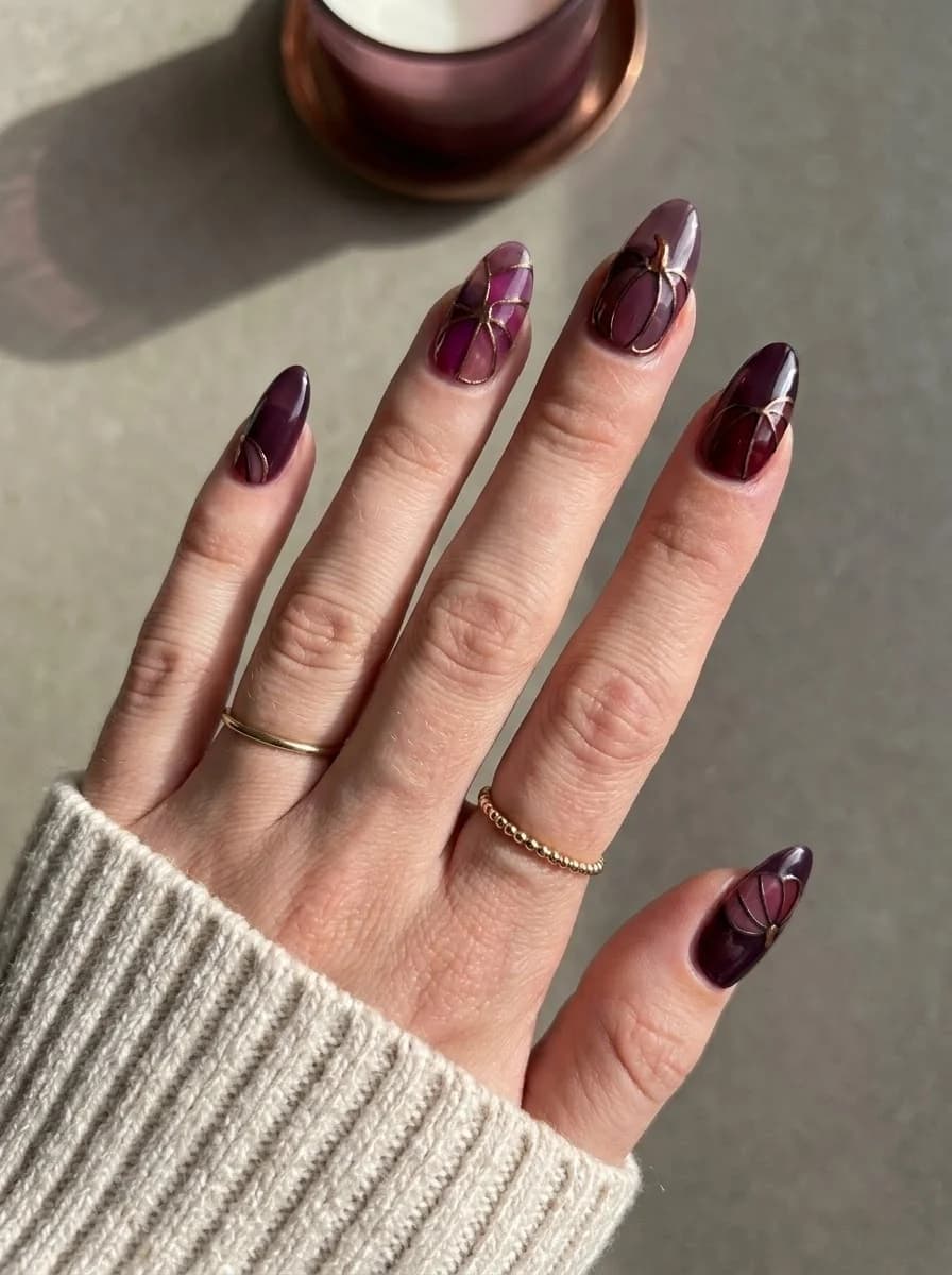 Plum Glass Pumpkin Nails with glossy translucent base and fine metallic gold outlines