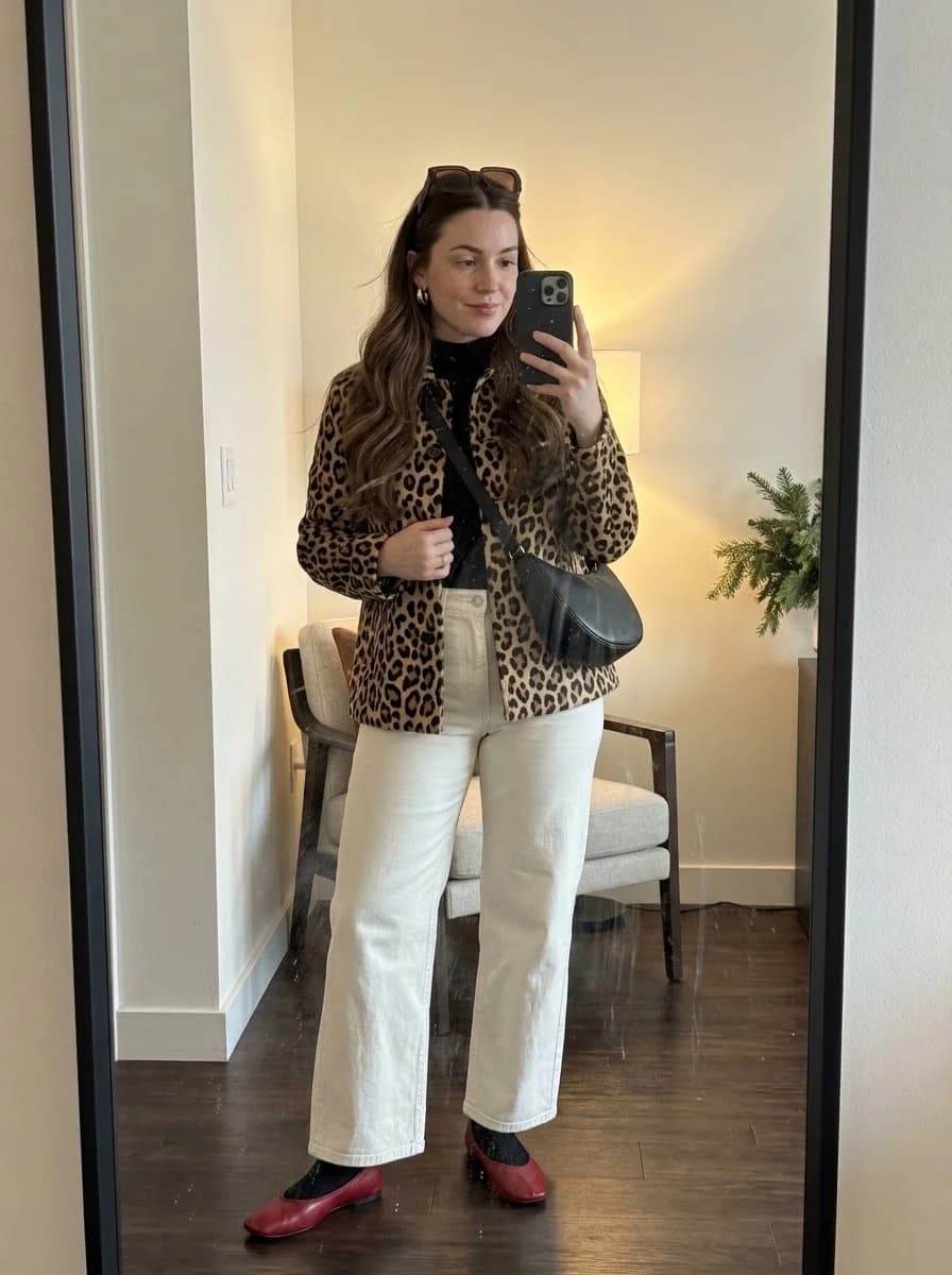 Leopard-print jacket over a black top and cream wide-leg jeans with red flats