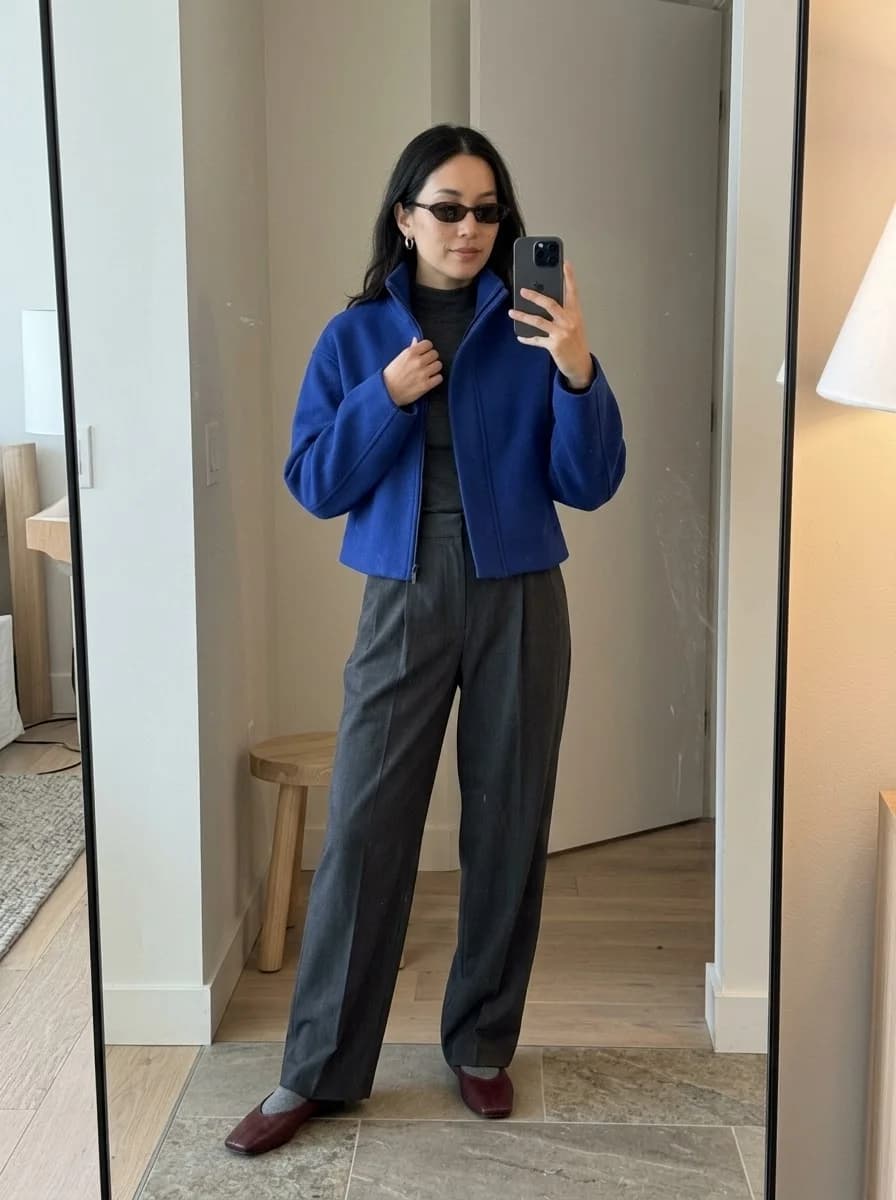 Cobalt blue cropped jacket over a charcoal turtleneck and wide-leg trousers
