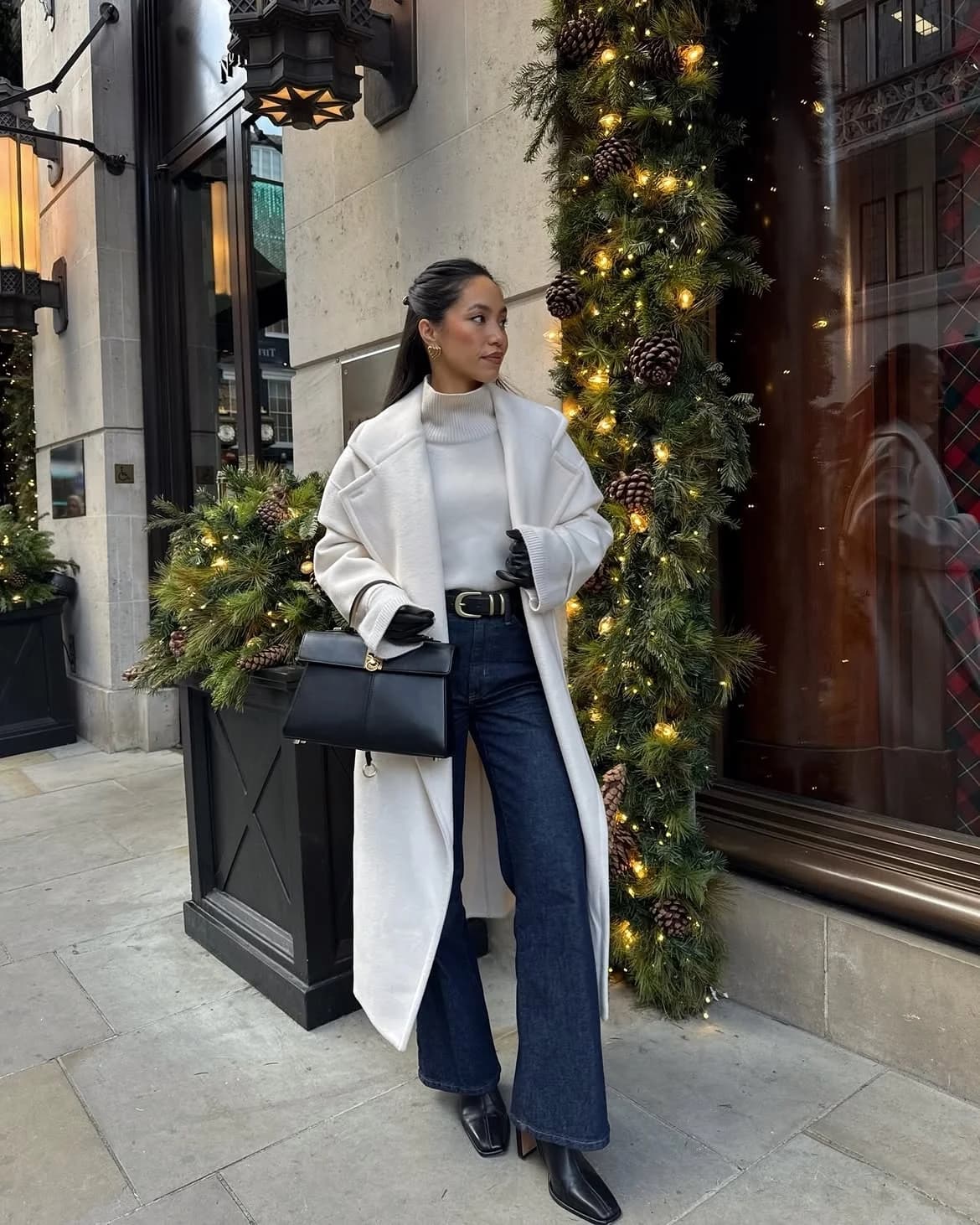 Long white coat over a white turtleneck and dark indigo wide-leg jeans