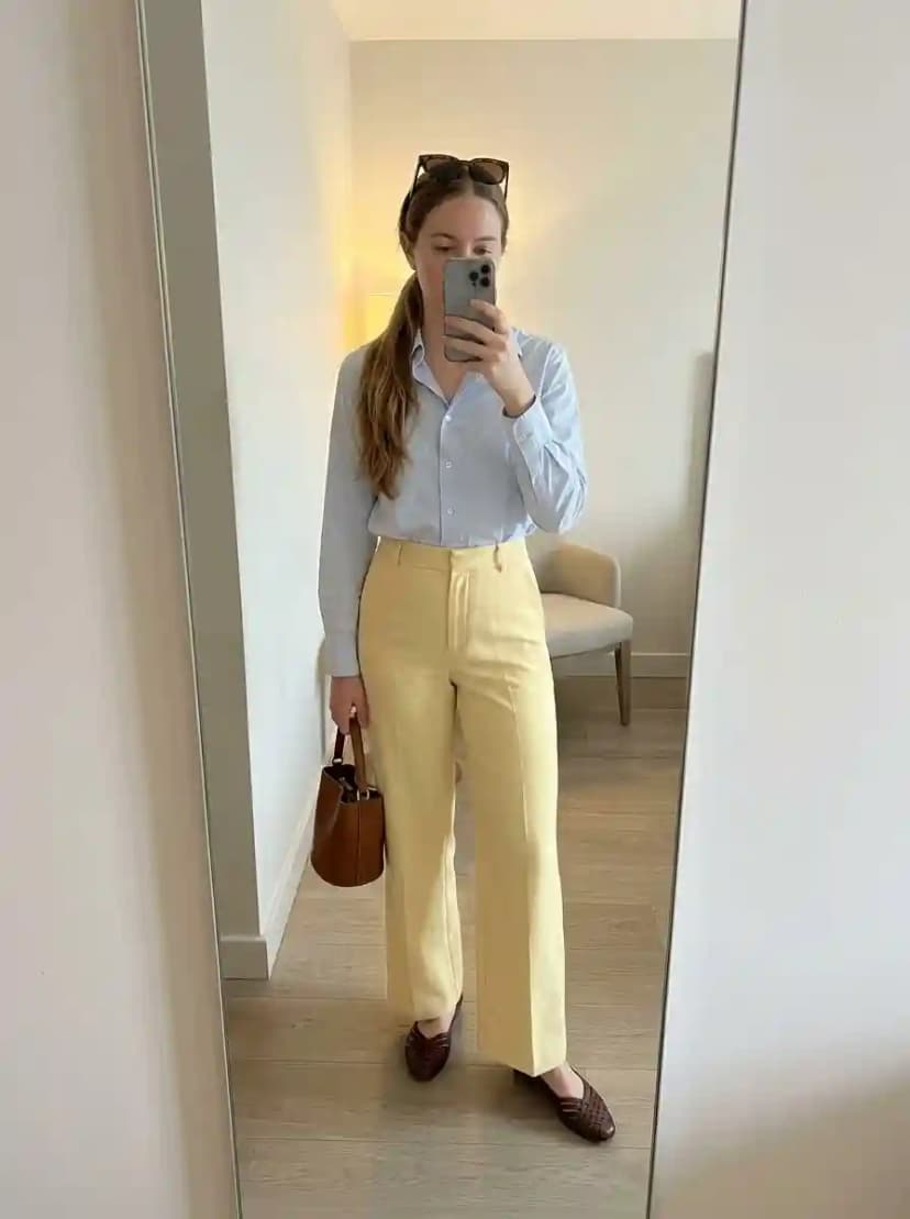 Light blue button-down shirt, pale yellow wide-leg trousers, and dark brown woven loafers