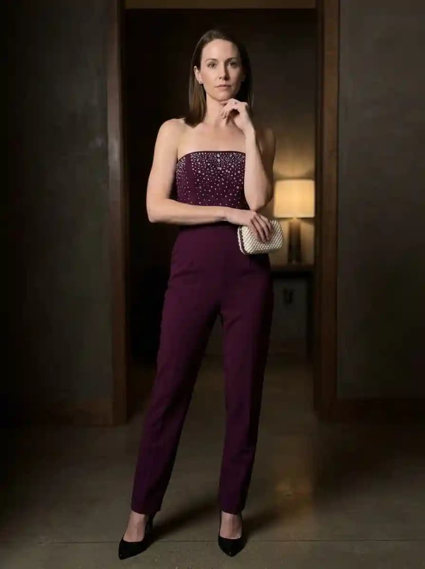 Deep plum strapless jumpsuit with pearl-embellished bodice and tailored straight-leg trousers