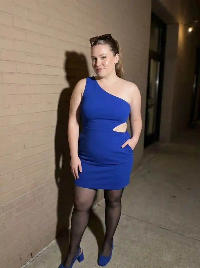 Royal blue one-shoulder bodycon mini dress with cutout at the left waist and black sheer tights