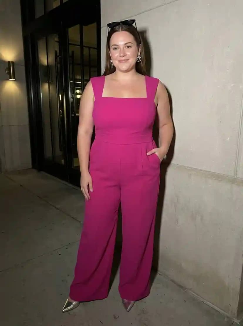 Bright fuchsia jumpsuit with square neckline, wide legs, and metallic silver pointed-toe pumps