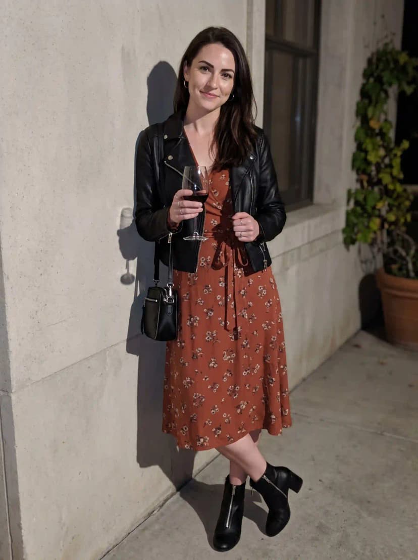 Rust floral print midi dress, black leather moto jacket, black ankle boots, and black crossbody bag