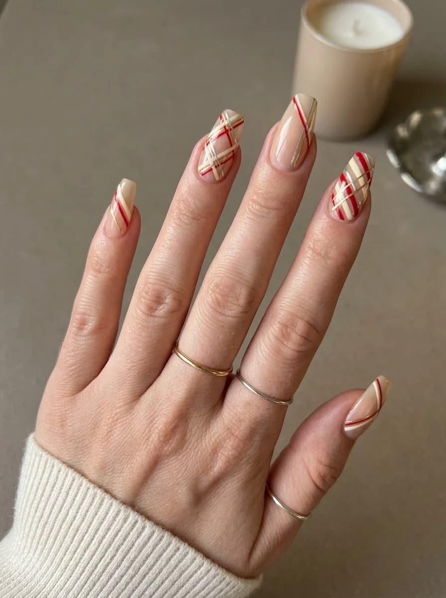 Nude nails with red and gold stripe accents