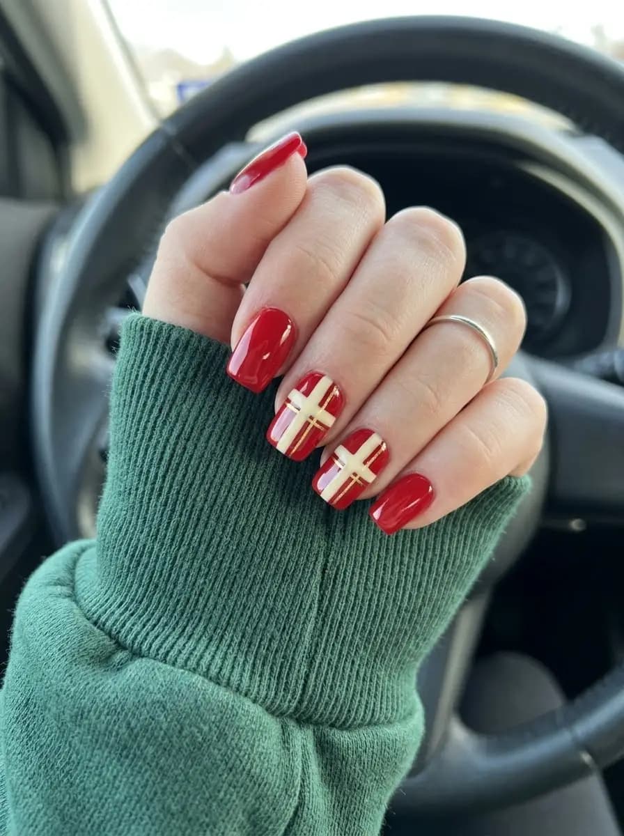 Glossy red gift-wrap Christmas nails with ribbon stripe pattern and metallic gold lines