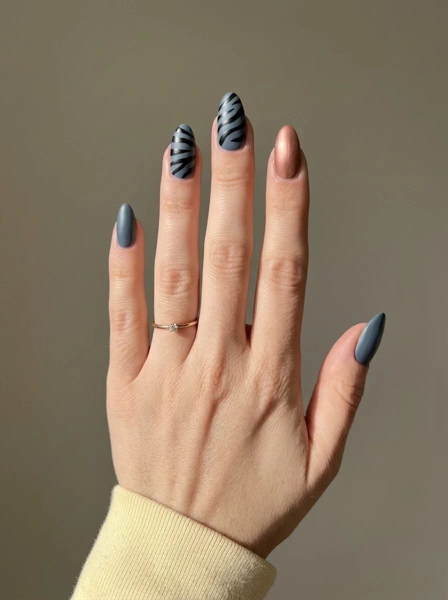 Short slate grey nails with graphic black stripes and a metallic rose gold accent nail