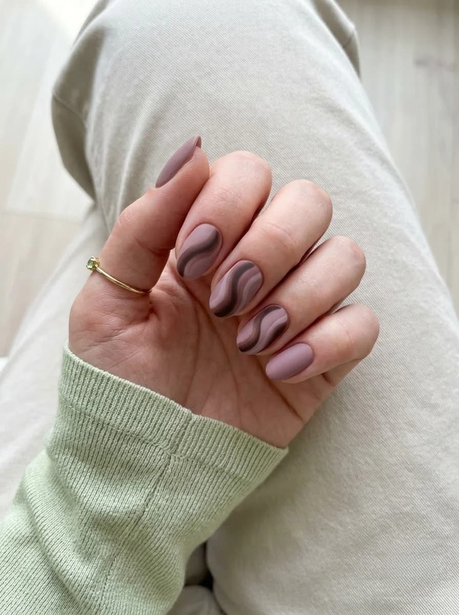 Short dusty mauve nails with layered chocolate brown wave stripes across center nails
