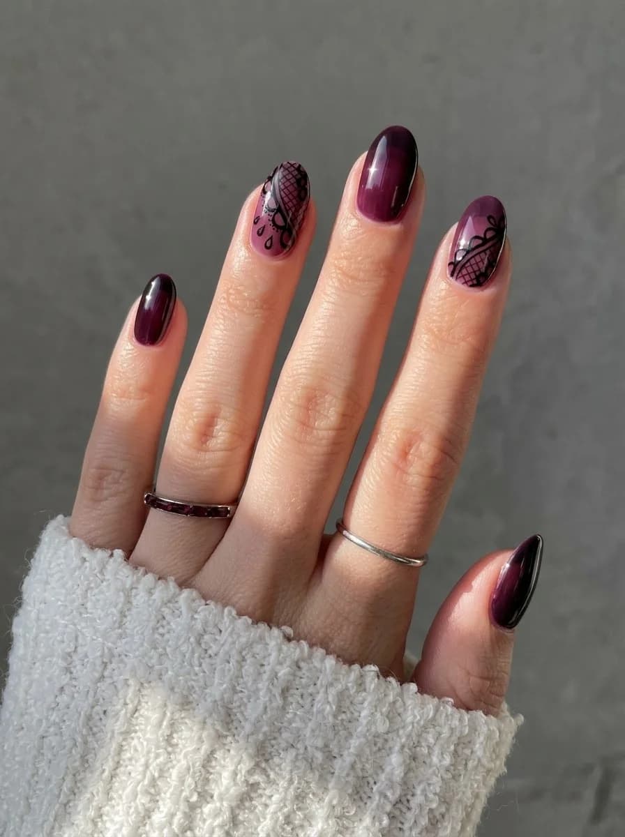Glossy plum ombre nails fading from soft berry to black plum with delicate black lace accents