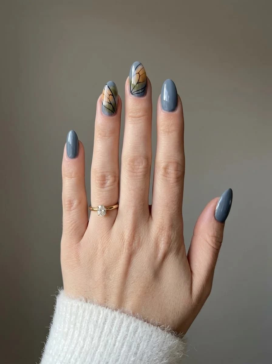 Cool slate grey nails with stained glass accent panels in amber, muted green, and black