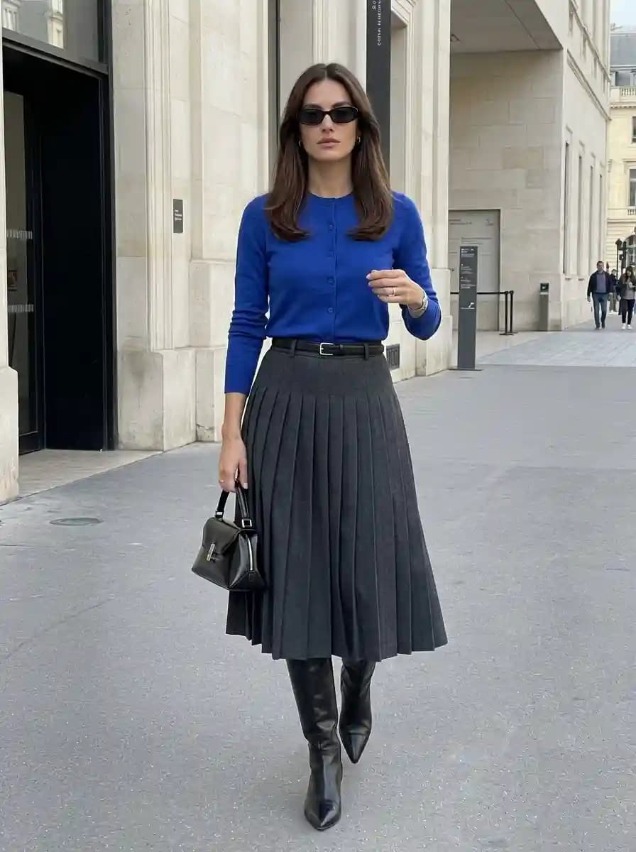 Bright cobalt blue button-front cardigan with dark charcoal grey knife-pleated midi skirt