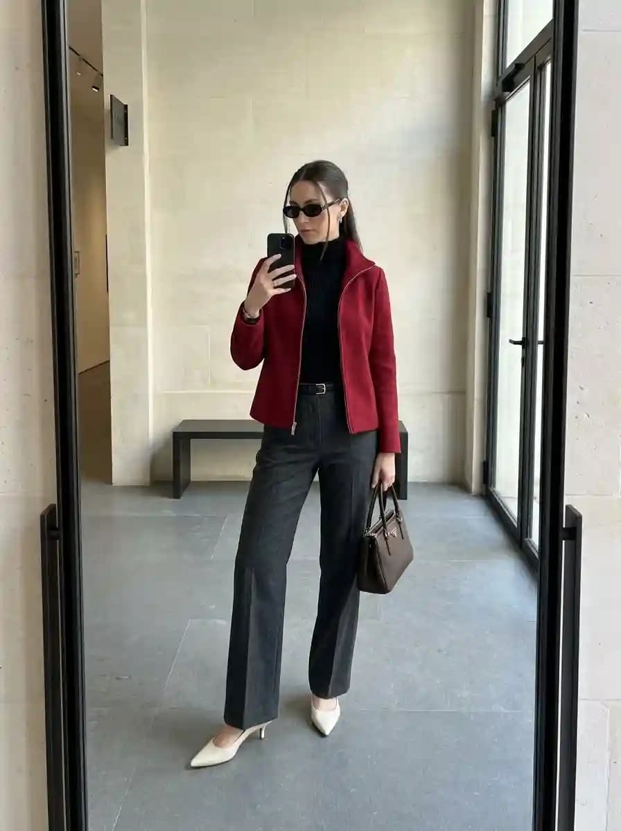 Black ribbed turtleneck with deep red cropped zip jacket and charcoal grey wide-leg trousers